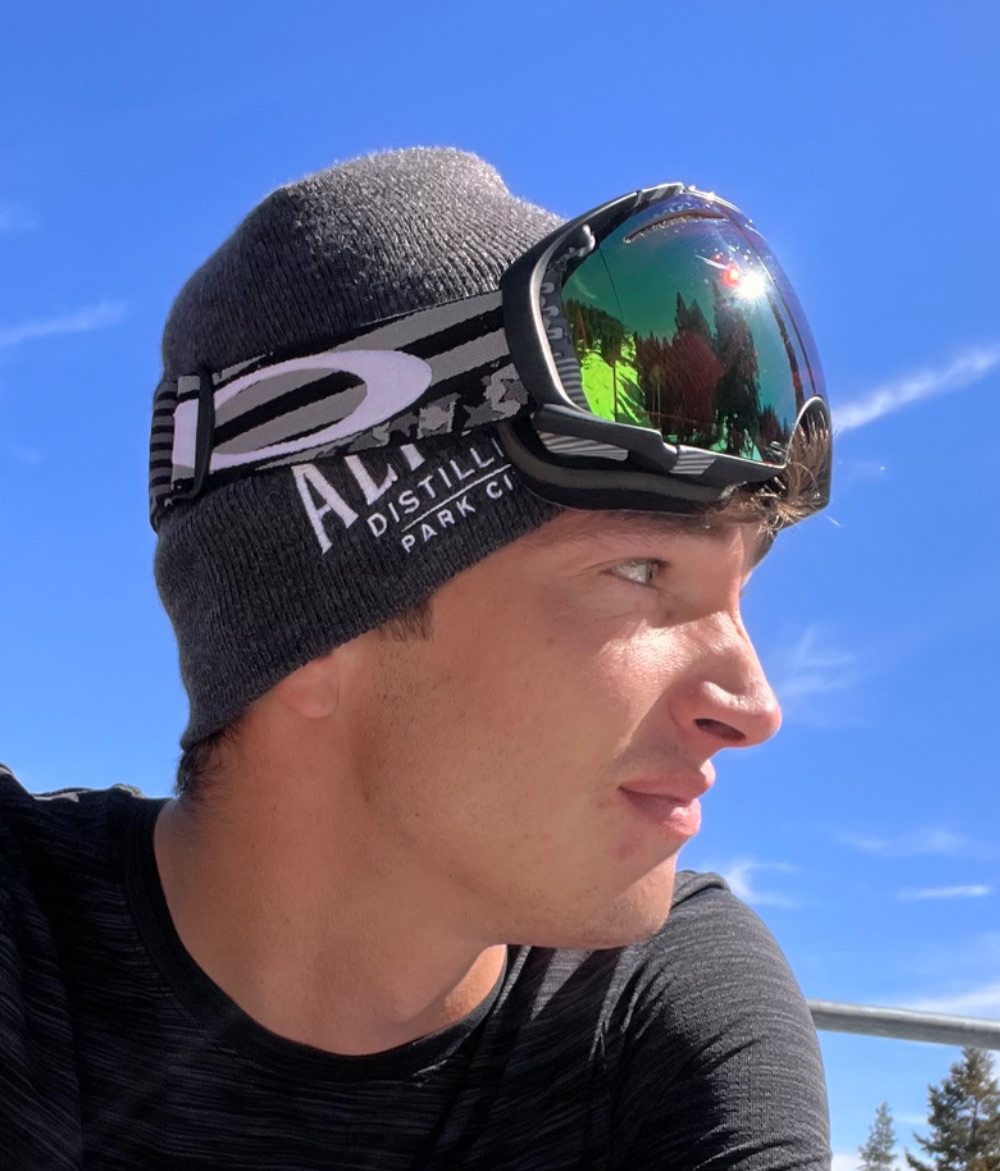 Kyle on a chairlift in a beanie and goggles