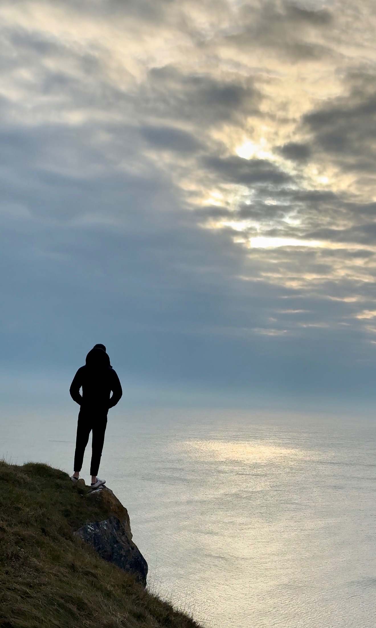 Kyle standing on the cliff edge above the sea