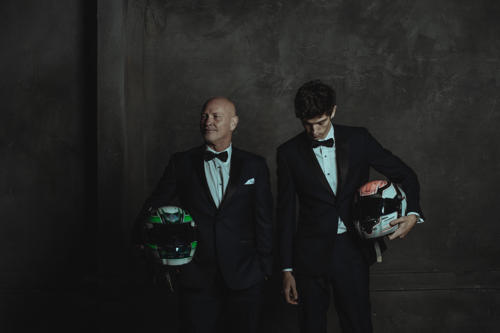 Kyle and Robert Masson in black tie, holding racing helmets
