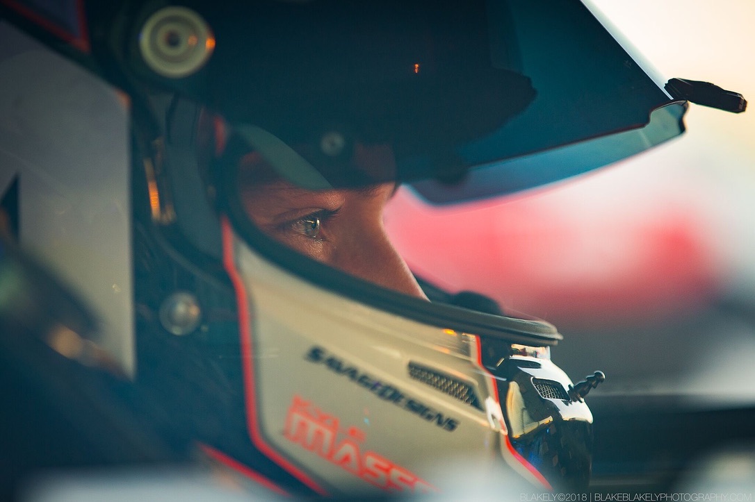 Kyle Masson in the cockpit, helmet on, golden hour