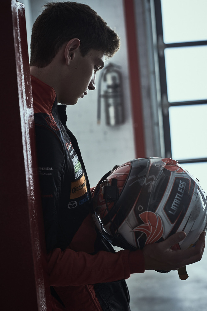 Race suit, helmet in hand